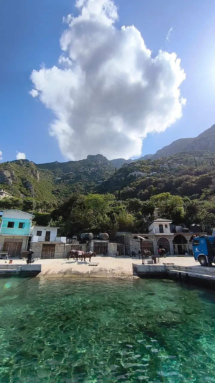 Причал у скита святой Анны на Афоне с кристально чистой водой и горами на фоне